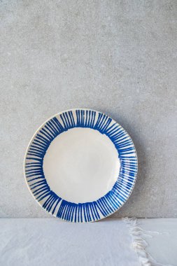 Gri arkaplanda mavi desenli beyaz plaka