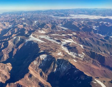 Karla kaplı tepeleri ve vadileri olan kayalık dağ manzarası