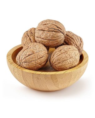 Cevizler beyaz arka planda, doğal ahşap kasenin içinde duruyor..