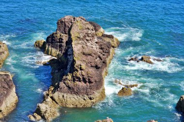 Kaya oluşumu berrak mavi okyanus dalgalarıyla çevrili