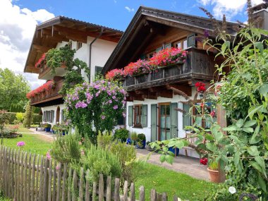 Renkli çiçekler ve yeşilliklerle çevrili iki büyüleyici ev.