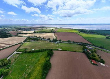 Mavi gökyüzünün altındaki yeşil ve kahverengi alanların hava manzarası