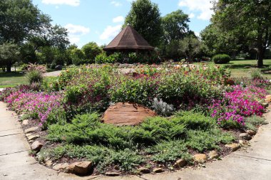 Kamu parkında çardağı olan dairesel çiçek bahçesi