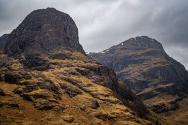İki Karanlık, Kayalık Dağ Zirvesi Yükseliyor Ağır Bulutlu Gökyüzü Altında