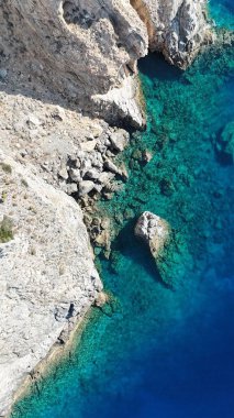 Aerial View of Rugged Limestone Cliffs Meeting Clear Turquoise Ocean Water
