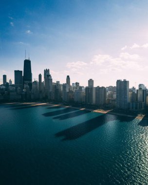 Şehir silueti, sakin suya yansıyan modern mimariyi gözler önüne seriyor.