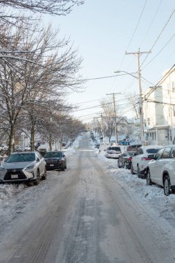 Revere, Massachusetts ABD - 16 Aralık 2021: Soğuk bir öğleden sonra park halindeki arabalarla kaplı bir mahalle sokağı.