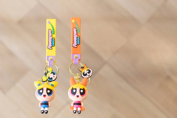 Bogota, Kolombiya - 22 Aralık 2022: İki güçlü puf kız anahtarlık, kabarcıklar ve bulanık bir arka planda çiçek