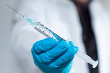 A doctor showing a syringe