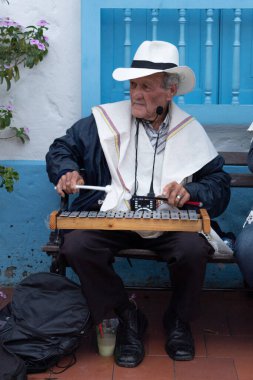Medellin, Colombia - July 30, 2022: An older traditional Colombian musician seated playing xylophone