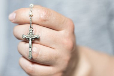 Gümüş bir tespih tutan beyaz bir elin yakınına.