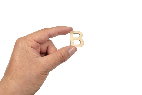 白い背景に孤立した小さな木製の文字Bを保持する人の手の閉じる — ストック写真
