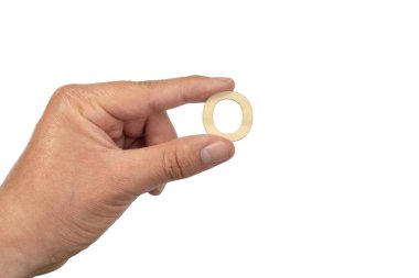 Beyaz bir arkaplan önünde ahşap bir harfi tutan bir el.