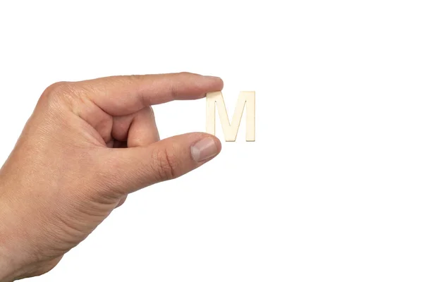 白地の前に木製の文字Mを持つ手 — ストック写真