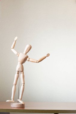Masanın üzerinde elleri havada duran bir manken.