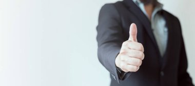 Beyaz-gri arka planda kravatsız, takım elbiseli bir iş adamı. Onay ve memnuniyet işareti. Web pankartı, boşluğu kopyala.
