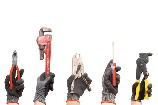 Hands wearing work gloves holding tools on a white background. Pliers, Pipe wrench, Riveter and other work tools. Image with copy space.