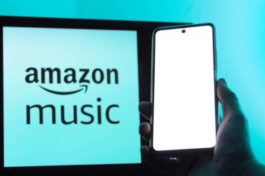 Bogota, Kolombiya - 12 Temmuz 2024: Bir erkek el Amazon Müzik logosu önünde boş ekranlı bir cep telefonu tutuyor. Talep üzerine müzik. Müzik platformu.