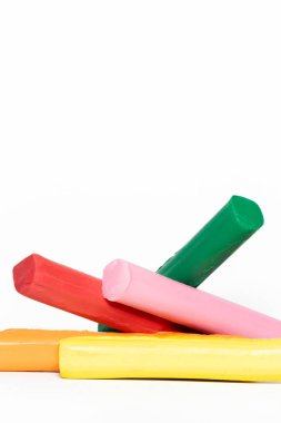 Renkli plastik çubukların çeşitliliği: kırmızı, pembe, yeşil, sarı ve turuncu düzensiz bir şekilde beyaz arka planda istiflenmiş.