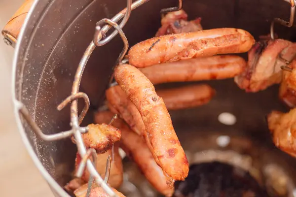 Chorizos ve sigara fıçısının içinde tütsülenen et parçaları. Yiyecek içme süreci.