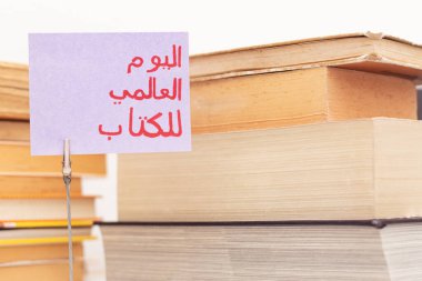 Dünya Kitap Günü 'nü anmak için Arapça el yapımı el yazısı içeren mor kağıda not.