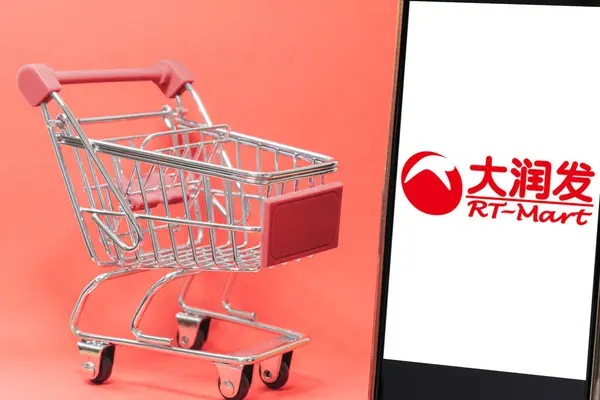 Bogota, Kolombiya - 24 Şubat 2025: Üzerinde RT-Mart logosu olan bir telefonun yanında kırmızı detaylar bulunan metal tramvay, Asya süpermarketi. Tayvan 'da perakende