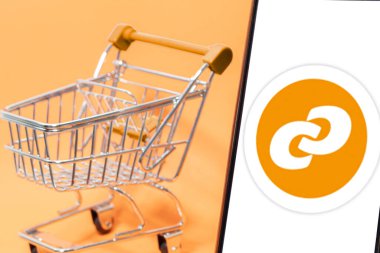 Bogota, Kolombiya - 24 Şubat 2025: Consum logosu, İspanyol süpermarketi boş bir alışveriş arabasının yanında.