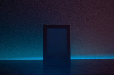 Karanlık odada dikey boyanmamış tuvali olan yaratıcı alan mavi ve fuşya aydınlatmalı, modern fütürist tarzlı.