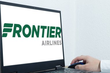 Bogota, Kolombiya - 14 Mayıs 2025: Frontier Airlines 'ın logosunu gösteren dizüstü bilgisayar, bir el fareyle bilgisayarı çalıştırıyor. Görüntü uçuş planlama ve yurt içi seyahate odaklandı
