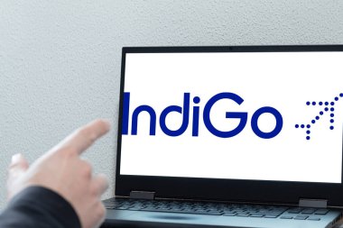 Bogota, Kolombiya - 14 Mayıs 2025: İndigo logolu dizüstü bilgisayar, Hindistan düşük maliyetli havayolu ve ofis ortamındaki ekranı işaret eden el yazısı. Düşük maliyetli uçuş kavramları ve dijital rezervasyonlar için ideal