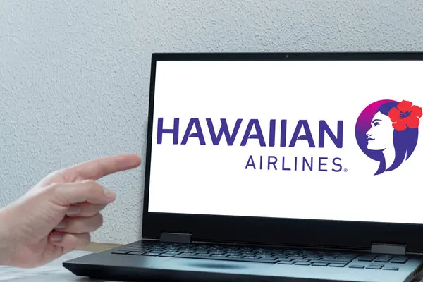 Bogota, Kolombiya - 14 Mayıs 2025: Havai Havayolları logosu olan dizüstü bilgisayar, ABD havayolu, bir el ekranı gösterirken, tropikal noktalara uçuş ve tatil planlama fikri
