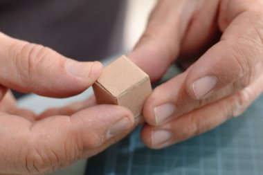 Ellerin küçük, zaten monte edilmiş bir karton kutuyu tutması.