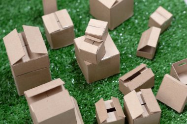 Sentetik çimen desenli küçük karton kutular.