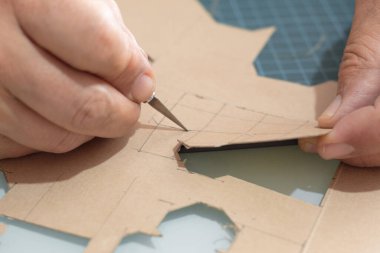 Kraft kartonunu el yapımı bir şablonla el yapımı bir bıçakla, minyatür kutular, geri dönüşüm ve sürdürülebilir ambalaj için el yapımı bir şablon ile birleştirmek.