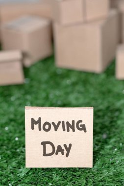 Karton kutular, taşınma konsepti, yeni ev ve ev organizasyonu arasında el yazısıyla taşınma günü tabelası