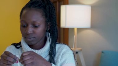 Young woman taking the stick out of the packet. Putting the soft part of the stick up her nose for a test flu and covid19