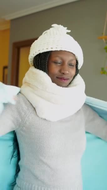 冷たい波と戦うために毛布で自分自身をカバー若い女性 居心地の良いリビングルームで冬服を着て Uhd垂直ビデオ — ストック動画