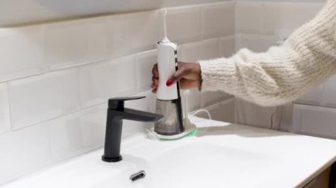 Çabasız Ağız Sağlığı: Banyo Havzasında Su Flosser Tankı Dolduran Kadın