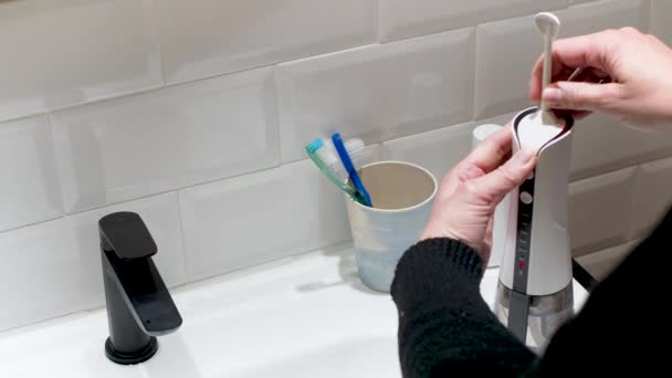 年轻女人的手在换他的家用牙刷 — 图库视频影像