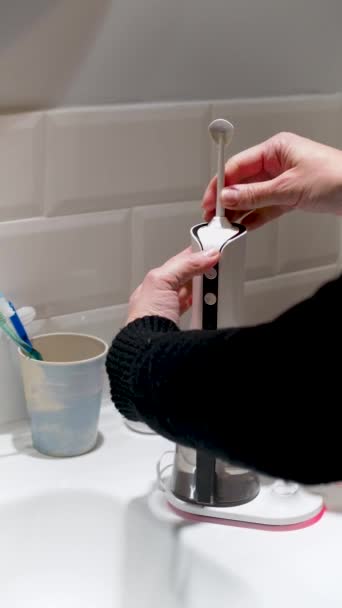 年轻女子的手正在更换他的家用牙刷尖4K垂直视频 — 图库视频影像