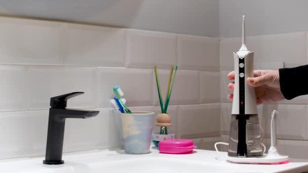 Young Woman Taking Placing Domestic Wireless Dental Water Flosser Bathroom — Vídeo de Stock