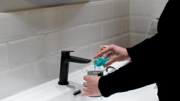 骨の折れる口腔健康 浴室の盆地で女性が水の花のタンクを満たす — ストック動画