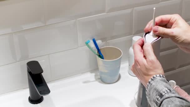 Young Man Hands Changing His Domestic Dental Water Flosser Tip — Stock videók