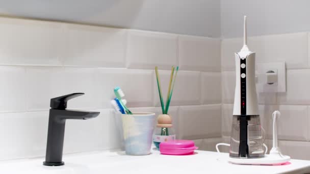 Young Man Taking Domestic Wireless Dental Water Flosser Bathroom Wash — Vídeo de Stock
