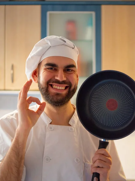 Retrato Joven Chef Barbudo Sonriendo Mientras Muestra Una Sartén Antiadherente — Foto de Stock
