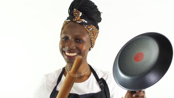 年轻的女厨师拿着一个不粘的平底锅和一个滚动的别针跳舞 背景是白色的 — 图库视频影像