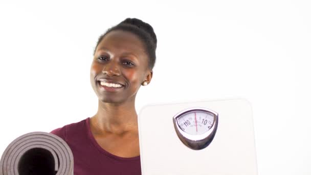体重計を持っている若い女性と白い背景に隔離されたヨガマット — ストック動画
