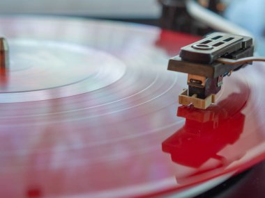 Kırmızı bir plağın üzerindeki iğnenin ayrıntıları. Vintage döner tablo.