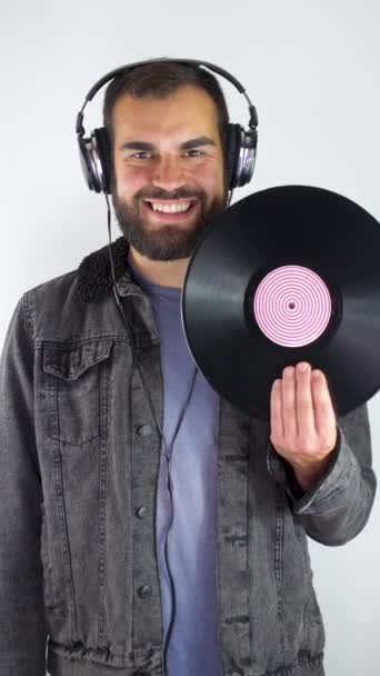 Young Bearded Man Using Headphones While Showing Vinyl Long Play — Stock Video