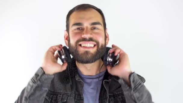 Ung Man Som Använder Hörlurar Samtidigt Ler Isolerad Vit Bakgrund — Stockvideo